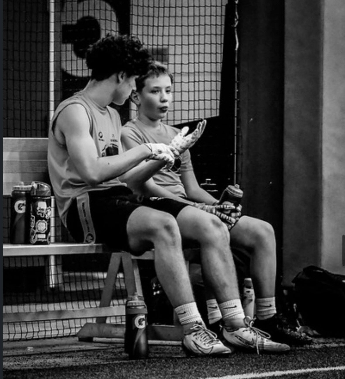 Two Royals athletes talking on the bench during a game